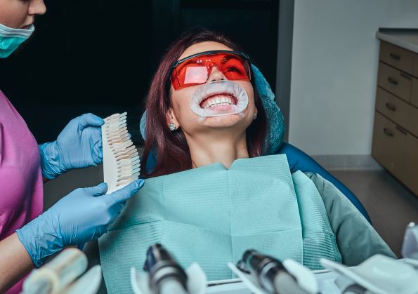 a woman dentist checks the level of teeth whitenin 2021 04 04 05 03 58 utc