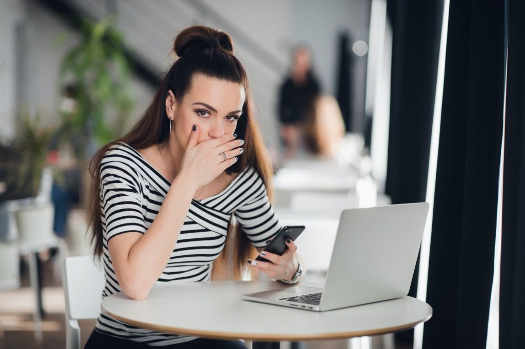 Closeup portrait anxious scared young girl looking at phone seeing bad news photos message with