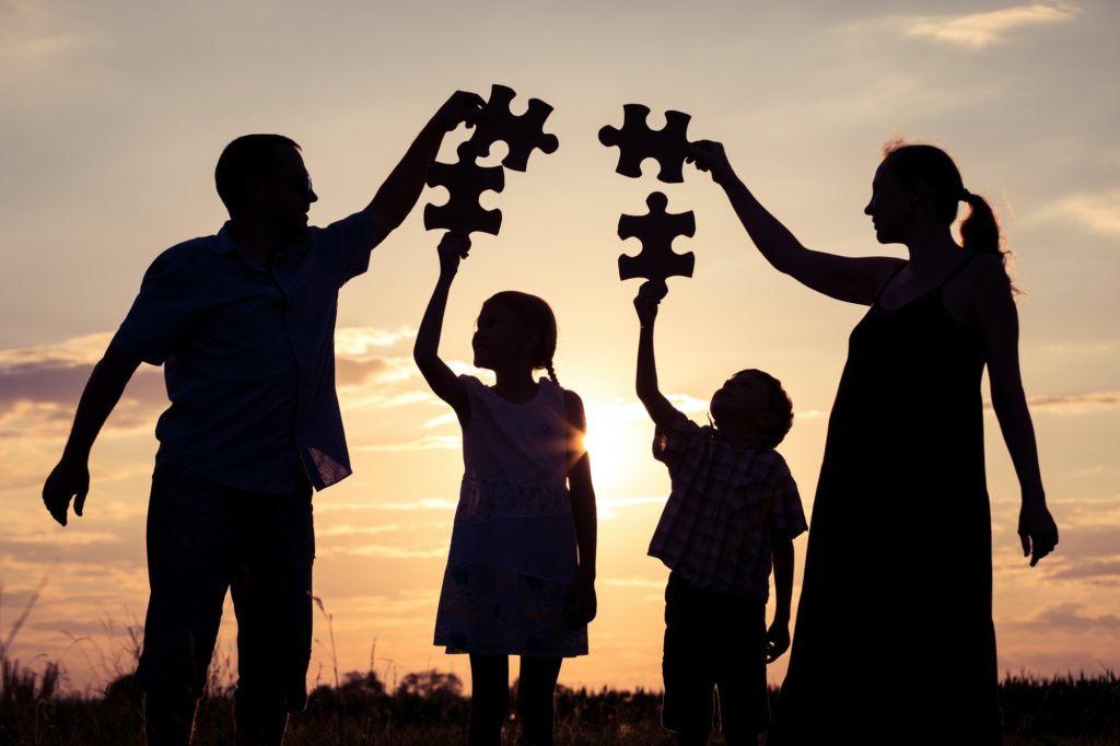 happy family standing in the park at the sunset time