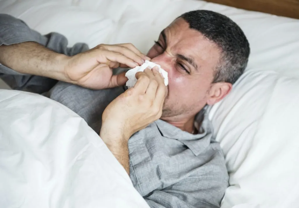 Sleep Apnea 22 man sneezing into a tissue