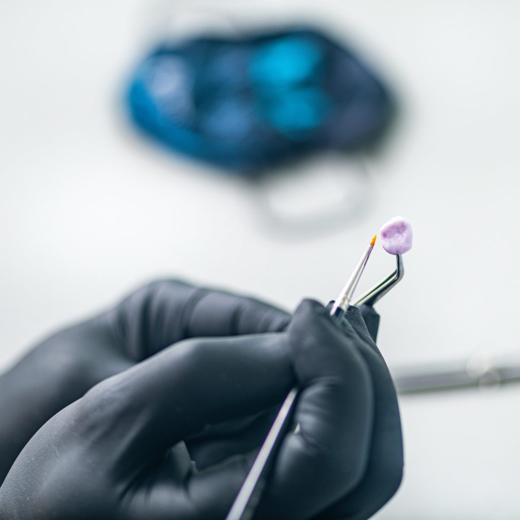 Teeth Prosthetics. Dental Technician Shaping and Polishing Dental Crown.