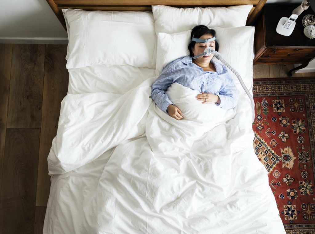 woman sleeping with an anti snoring mask